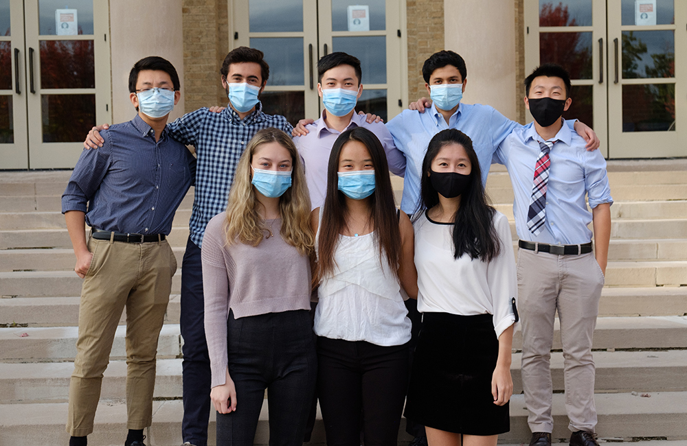 The Vita Innovations team poses for a photo outside, all wearing masks.