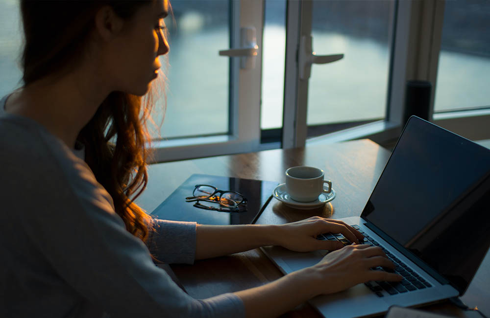 A woman sits at a laptop.