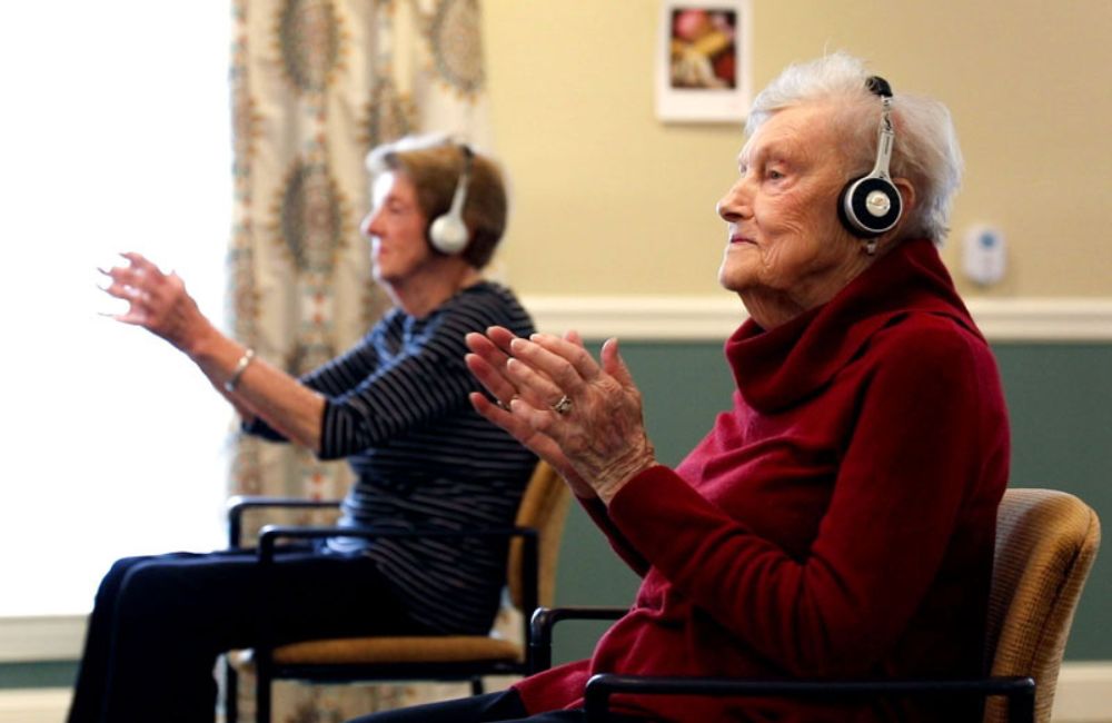 Two older adults with headphones on.